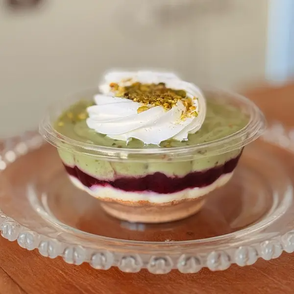 Farofa de Biscoito, Um Delicioso Creme de Pistache com Pedaços de Pistache, Geleia Artesanal de Frutas Vermelhas, Nosso Magnifico Creme de Ninho, Finalizado com Chantininho e Farelo de Pistache. - Aproximadamente 250ml -