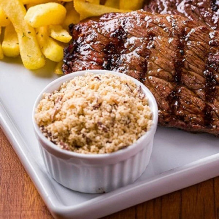 Farofa feita com carinho e temperos tradicionais, numa porção prática para realçar o sabor do seu prato.