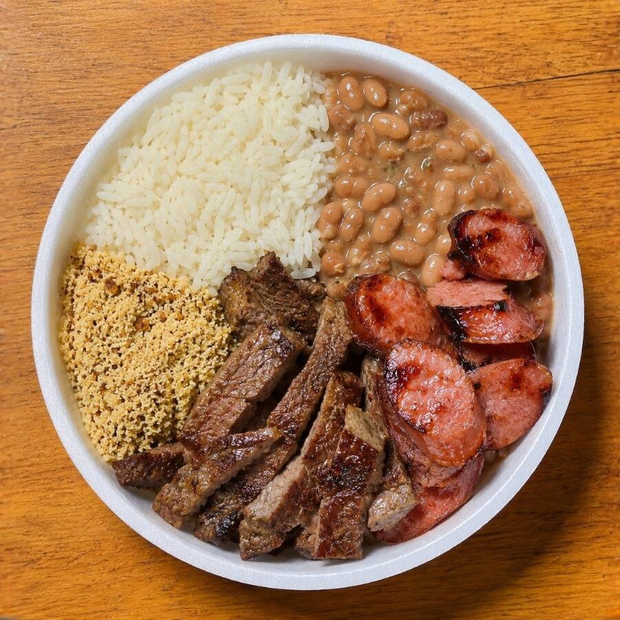 Arroz soltinho, tiras de contrafilé, linguiça de churrasco e farofa temperada. Prato completo, saboroso e bem servido. Porção de 600 g. Serve 1 pessoa.