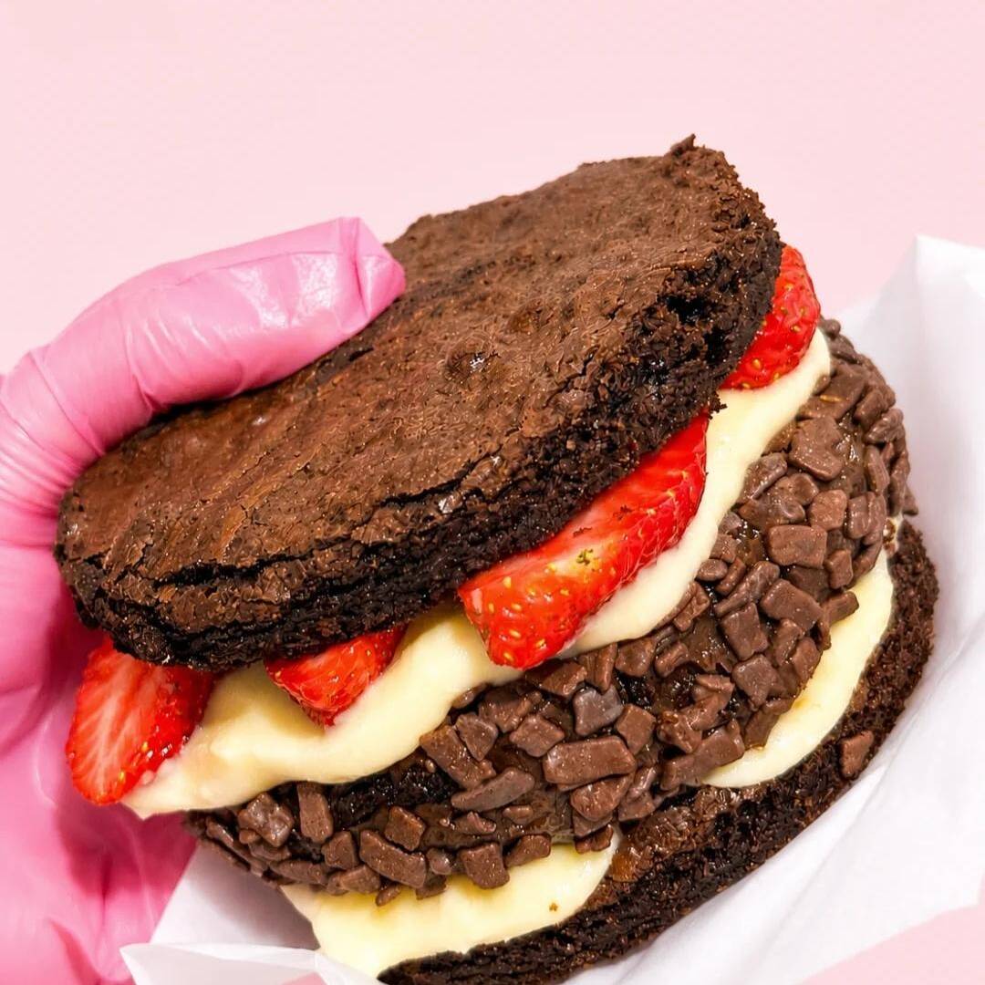 Nosso X-Bolo de Brownie chegou para conquistar os apaixonados por chocolate! Duas camadas de brownie super macio, recheadas com muito creme, morangos fresquinhos e um irresistível brownie coberto com granulado de chocolate.
🍫 Muito chocolate
🍓 Morangos frescos
❤️ Cremoso e surpreendente em cada mordida