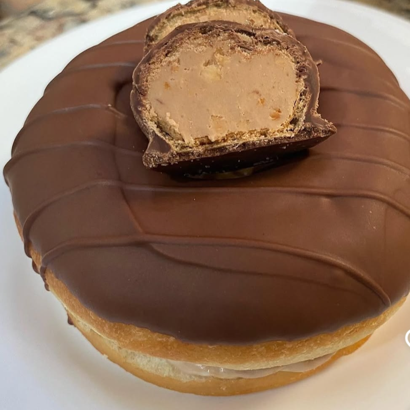 Deliciosa massa de Donuts americano crocante e macia por dentro, recheada com mousse de Nuts crocante , finalizado com chocolate meio amargo derretido .04 und. Tamanho americano.