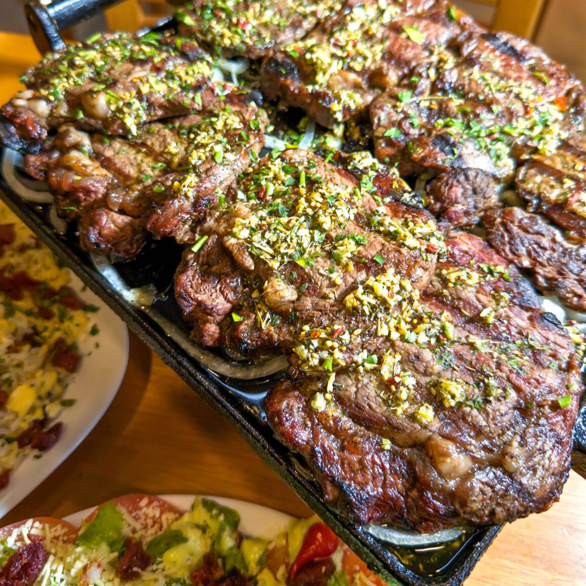 Corte nobre de Ancho Grill argentino servido com Aligot do Cheff. Servido com batata fritas, farofa artesanal, arroz biro biro, salada do Cheff e molho Grill. Serve 4 pessoas.