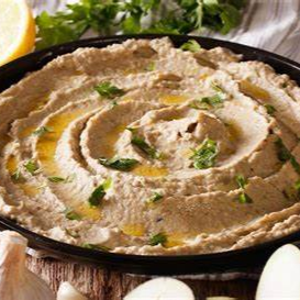 Saborosa pasta de berinjela assada, temperada com molho à base de gergelim e limão, acompanha pão árabe