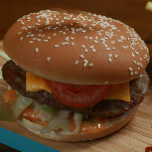 Pão grande com gergelim, carne bovina de 90g, queijo cheddar, molho billy jack , alface americana e tomate