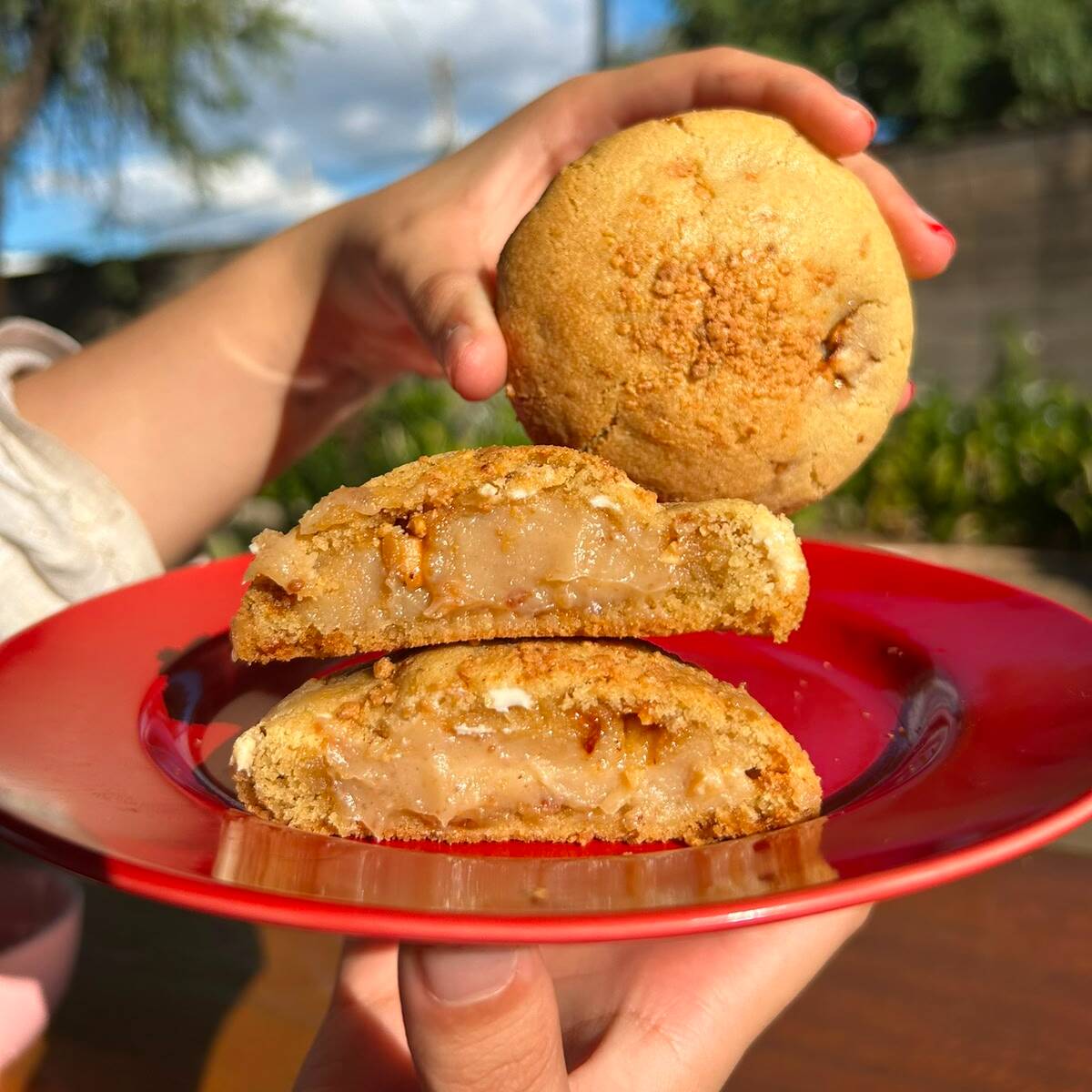 Um pedacinho do arraiá em forma de cookie! Massa amanteigada com chocolate branco e paçoca para saborizar, recheada com brigadeiro de paçoca e finalizada com uma chuva de paçoca por cima.
