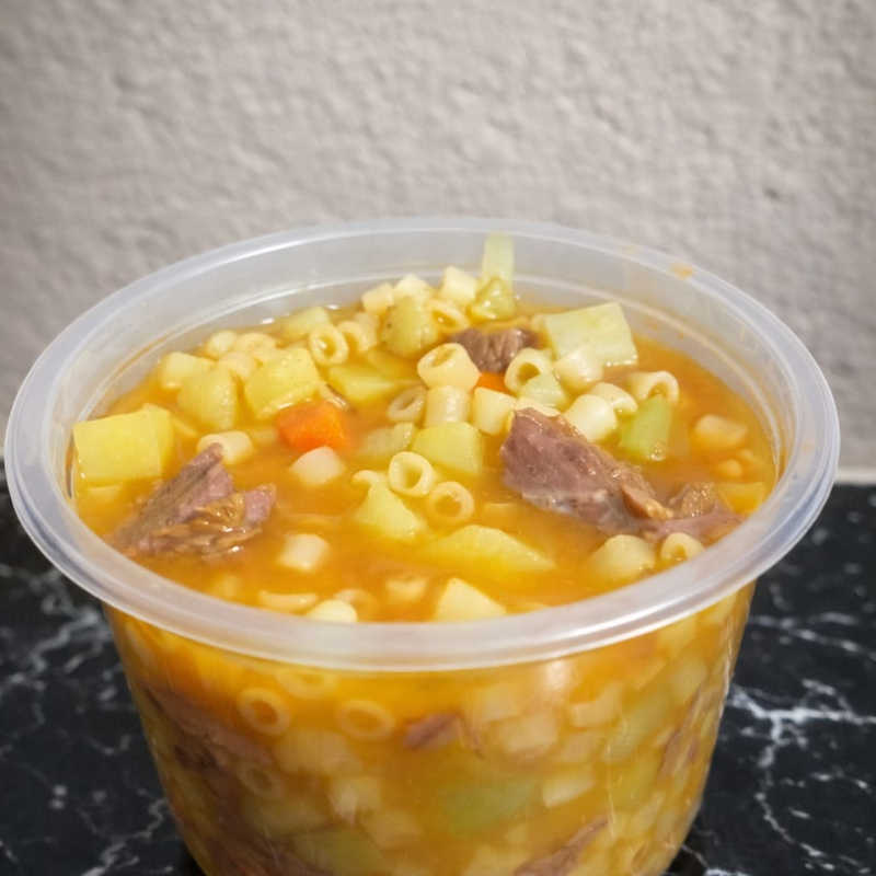Caldo bem quentinho, feito com músculo macio que desmancha na boca, batata, cenoura, chuchu e macarrão cozidos no ponto certo. Temperado com carinho, com aquele sabor caseiro que lembra comida de mãe. Espesso, saboroso e super bem servido — perfeito para aquecer a noite e matar a fome de verdade. Cada colherada é conforto puro 🤤🔥
