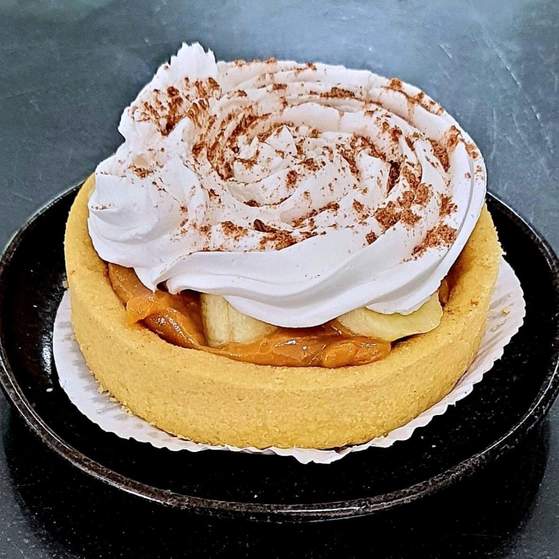 Uma deliciosa combinação de camadas irresistíveis! Base crocante de biscoito amanteigado, um generoso recheio de doce de leite cremoso, fatias frescas de banana e cobertura de chantilly leve e aveludado, finalizada com uma pitada de cacau em pó. Uma sobremesa perfeita para adoçar seu Dia!