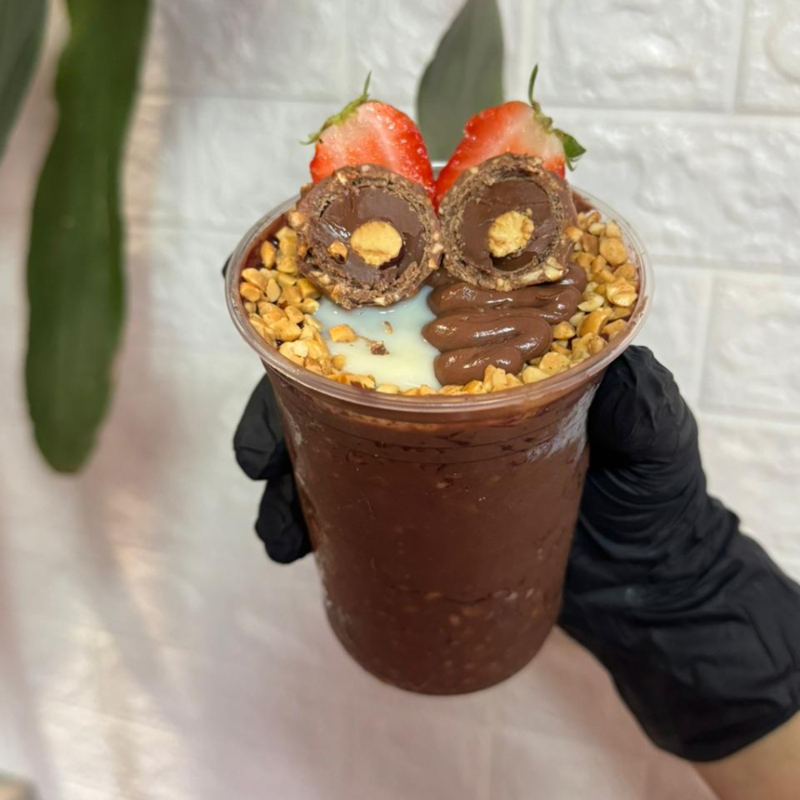 Açaí · Ferrero Rocher · creme de avelã · amendoim granulado · leite condensado · e fruta a sua escolha. O copo mais sofisticado do Cantinho Tropical. Açaí premium com amendoim granulado crocante, creme de avelã e a luxuosa bola de Ferrero Rocher coroando tudo. Uma experiência gourmet que você não espera encontrar num copo de açaí — e é exatamente isso que o torna inesquecível. Para os momentos especiais, ou quando você simplesmente sabe que merece o melhor.
