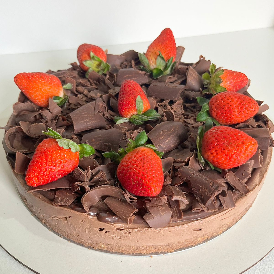 Base crocante de biscoito de chocolate, com delicioso mousse de chocolate nobre, finalizado com ganache, raspas de chocolate nobre e morangos. Aprox. 1kg