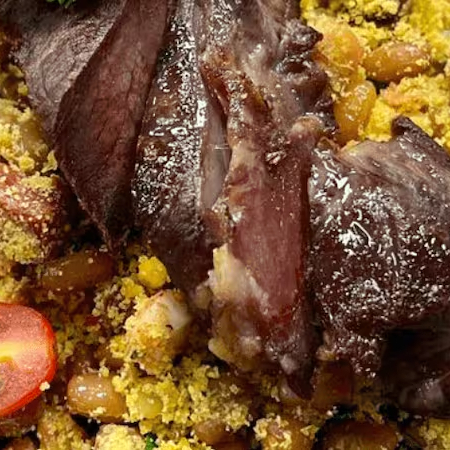 Suculenta carne assada com feijão tropeiro nordestino de raiz . Esta refeição acompanha : Arroz e feijão preto