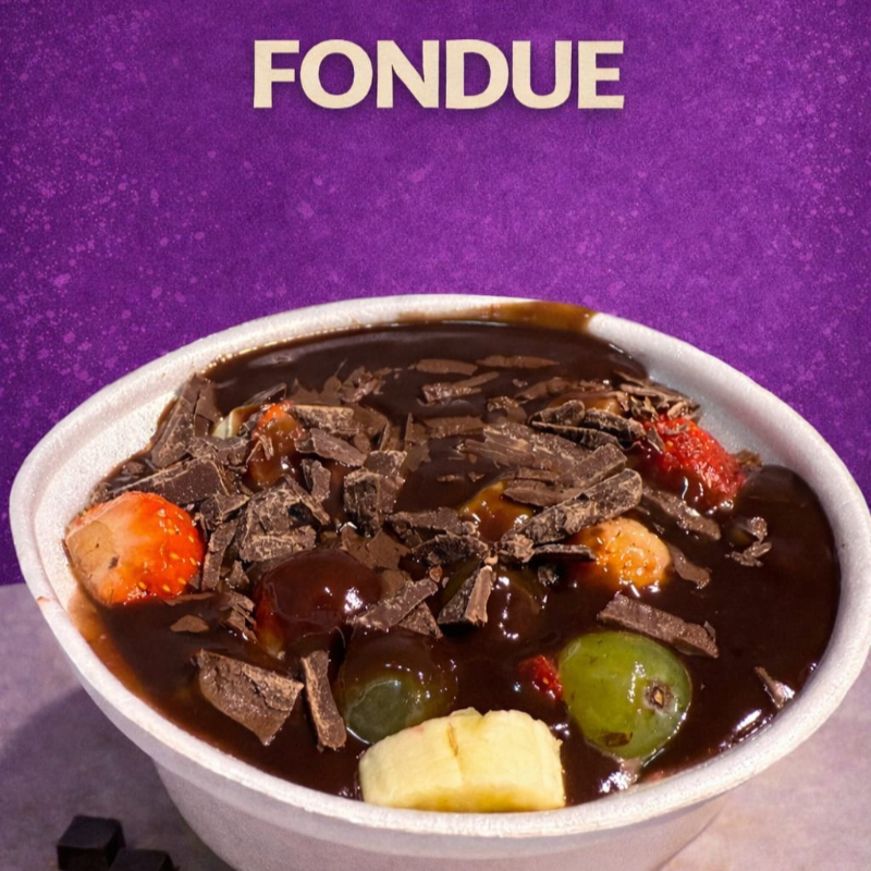Fondue de chocolate artesanal servido com uma seleção de frutas frescas, uma experiência deliciosa e divertida.