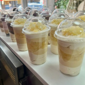 Copo composto por: Mousse de ninho Brigadeiro branco Pedaços de abacaxi em calda Pedaços de massa folhada