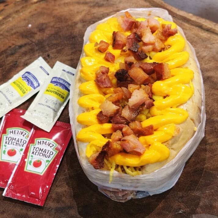 Delicioso hot dog com 2 salsichas, molho especial, batata palha, bacon, milho, e Cheddar. Acompanha maionese e ketchup. Não Realizamos Troca De Ingredientes!!!