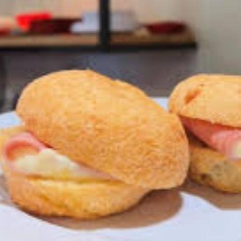 Pão de queijo macio com um recheio generoso de presunto e queijo derretido, uma combinação clássica e irresistível.