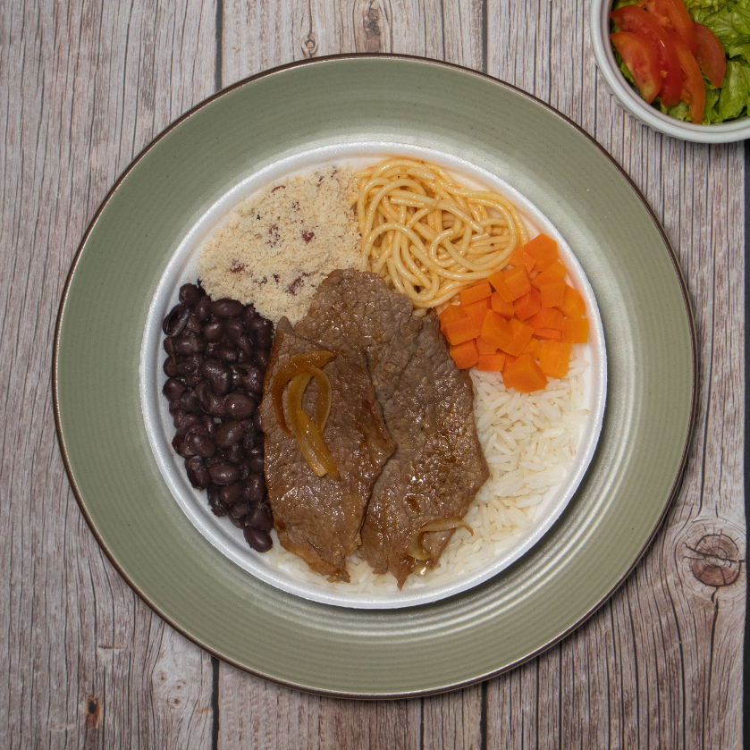 Bife acebolado, arroz, feijão preto, macarrão, farofa e acompanhamento do Dia.