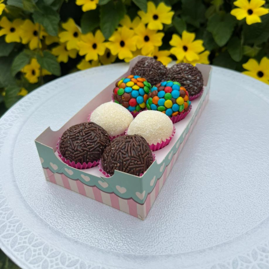 Caixa com 8 brigadeiros artesanais, sendo 4 sabores incríveis, com 2 unidades de cada: Oreo – brigadeiro cremoso com pedaços crocantes de Oreo, perfeito para quem ama chocolate com textura. Confete – clássico brigadeiro de chocolate coberto com confetes coloridos, trazendo alegria e sabor em cada mordida. Ninho – brigadeiro suave e aveludado feito com leite Ninho, doce na medida certa e irresistível. Chocolate – o tradicional brigadeiro de chocolate, intenso, cremoso e feito com ingredientes de qualidade. Ideal para adoçar o Dia, presentear ou matar aquela vontade de um doce especia