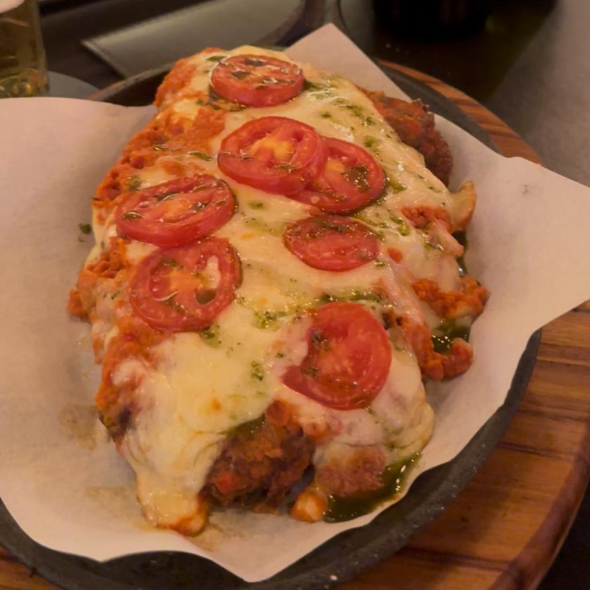 A versão perfeita para quem ama frango! Um suculento filé de frango empanado, coberto com nosso molho de tomate caseiro e uma camada generosa de queijo muzzarela derretido e gratinado e emulsão de albahaca. A mesma delícia da napolitana clássica, agora com a suavidade do frango. Acompanha batatas fritas.