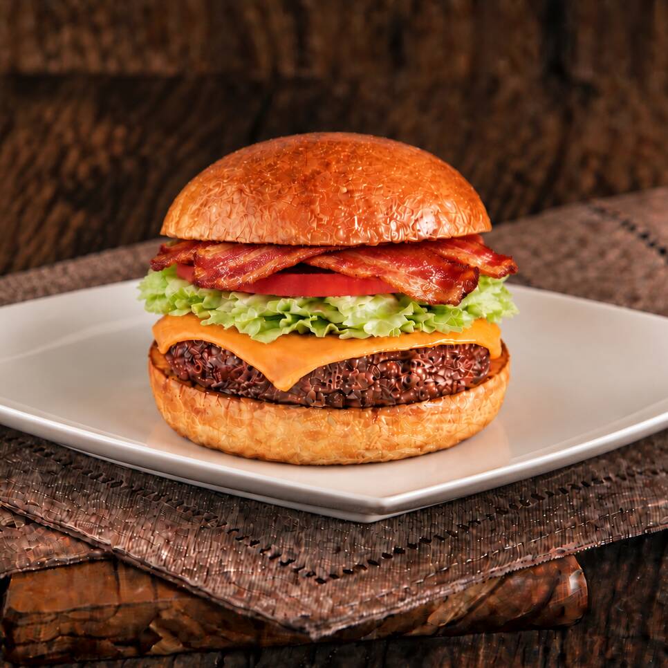 Hambúrguer artesanal, blend angus de costela (150g) grelhado, queijo prato derretido, fatias de bacon crocante, rodelas de tomate fresco, alface e maionese da casa, servido no pão brioche. Uma opção simples e deliciosa, perfeita para quem valoriza sabor autêntico e ingredientes de qualidade.