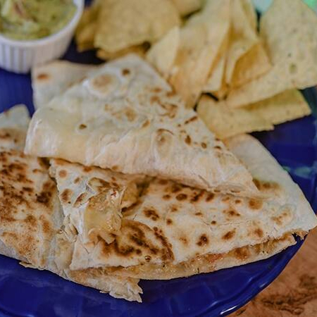 Nossa 'Quesadilla de Calabresa' é uma autêntica homenagem à icônica Frida Kahlo. Ela apresenta uma tortilla de trigo cuidadosamente tostada, trazendo uma textura irresistível. Cortada em quatro porções generosas, ela é recheada com um mix de queijos de alta qualidade, que derrete suavemente, criando uma combinação perfeita com a calabresa bem temperada e o tomate fresco e suculento. Este prato é uma verdadeira obra de arte culinária, cheia de sabor e personalidade, assim como Frida.