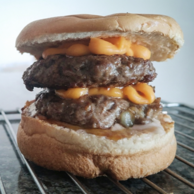 Pão macio recheado com duplo hambúrguer artesanal, grelhado na chapa, coberto com cheddar cremoso e intenso, derretido no ponto certo. Um lanche forte, suculento e cheio de sabor, ideal pra quem ama cheddar de verdade.