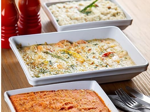 Camarões refogados com tomate, cebola, pimentões e cheiro-verde na manteiga da terra.coberto com molho à base de coco. Gratinado com queijo coalho. Servido com purê de abóbora e arroz cremoso de castanha de caju.Tamanho do camarão nesse prato: 18g.