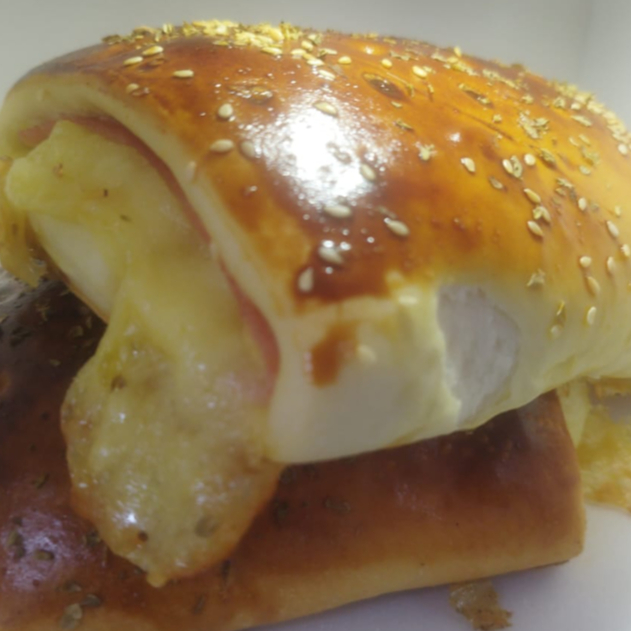 Delicioso salgado assado recheado com queijo e presunto.