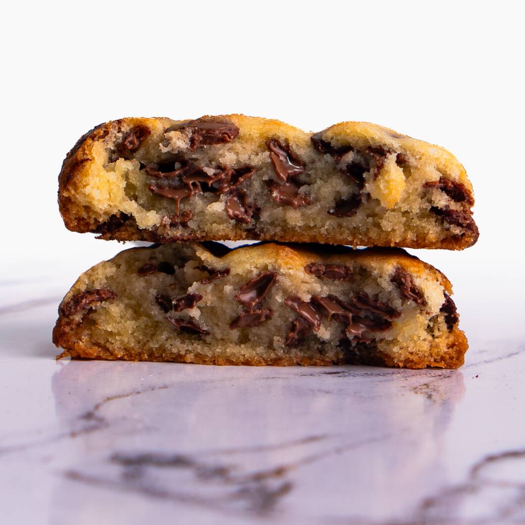 Nosso cookie de chocolate é feito com massa de baunilha e Muitas gotas de chocolate nobre ao leite e meio-amargo. Cada mordida é uma explosão de sabor: crocante por fora e macio por dentro.