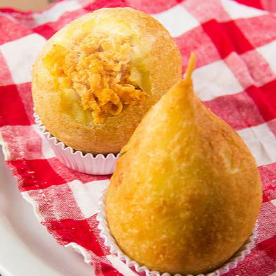 02 Coxinhas de Frango douradas, crocantes por fora e recheadas com frango bem temperado. Uma opção prática e saborosa para qualquer hora do Dia.