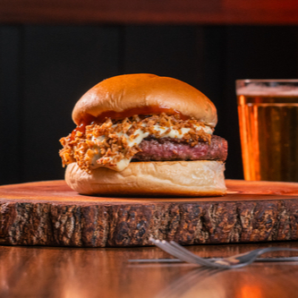 Pão de Brioche, Burguer Artesanal de 160g, Molho de Queijo, Cebola Crispy e Ketchup.