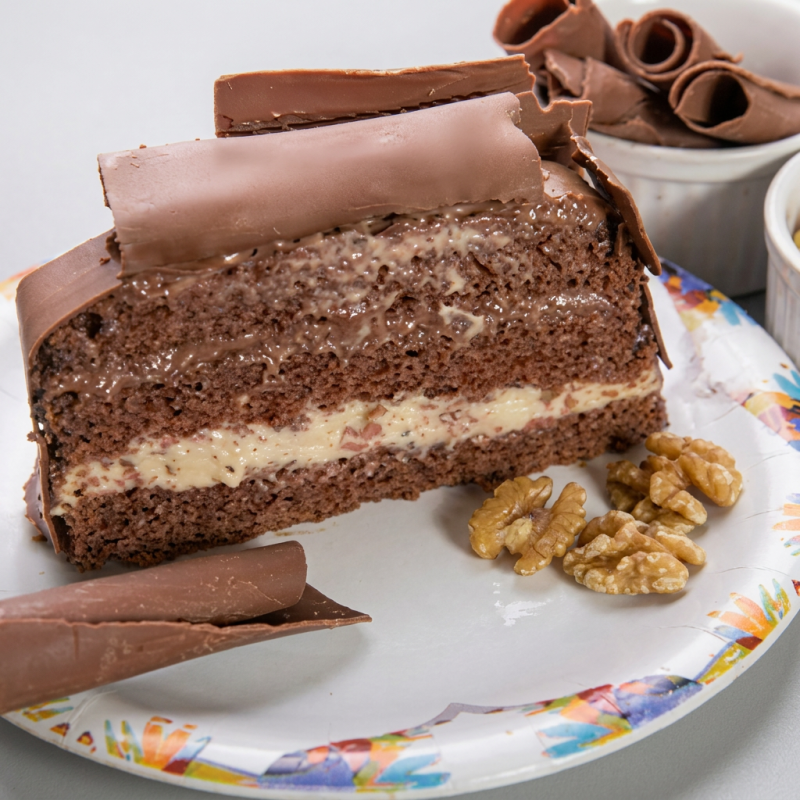 Pão de ló de chocolate super macio, recheado com brigadeiro cremoso e doce de nozes, coberto com mais brigadeiro e finalizado com raspas de chocolate ao leite. Uma combinação clássica com um toque especial que derrete na boca!