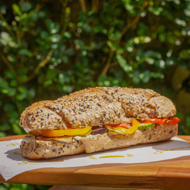 Sanduíche no pão multigrãos com creme de castanha (Cream cheese vegano) abobrinhas, berinjelas e pimentões vermelhos e amarelos.