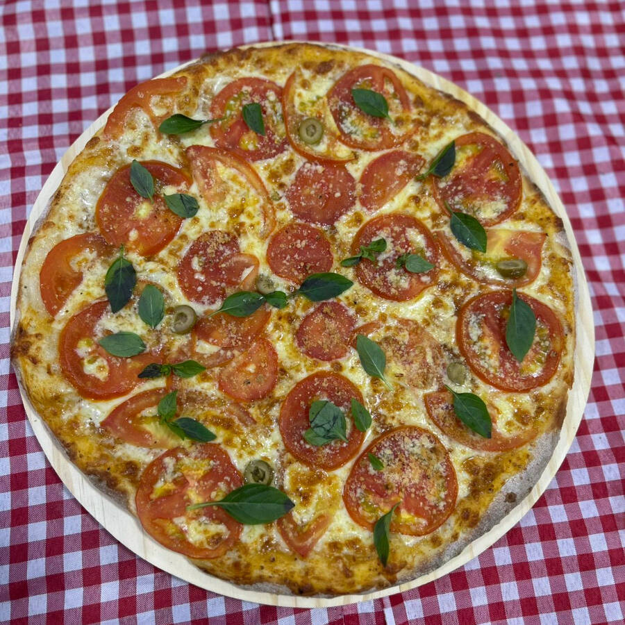 Deliciosa pizza artesanal mista, 08 fatias, feita com massa fina e tradicional , coberta com molho caseiro , mussarela, bacon, presunto, calabresa e finalizada com tomate, cebola, azeitona e orégano