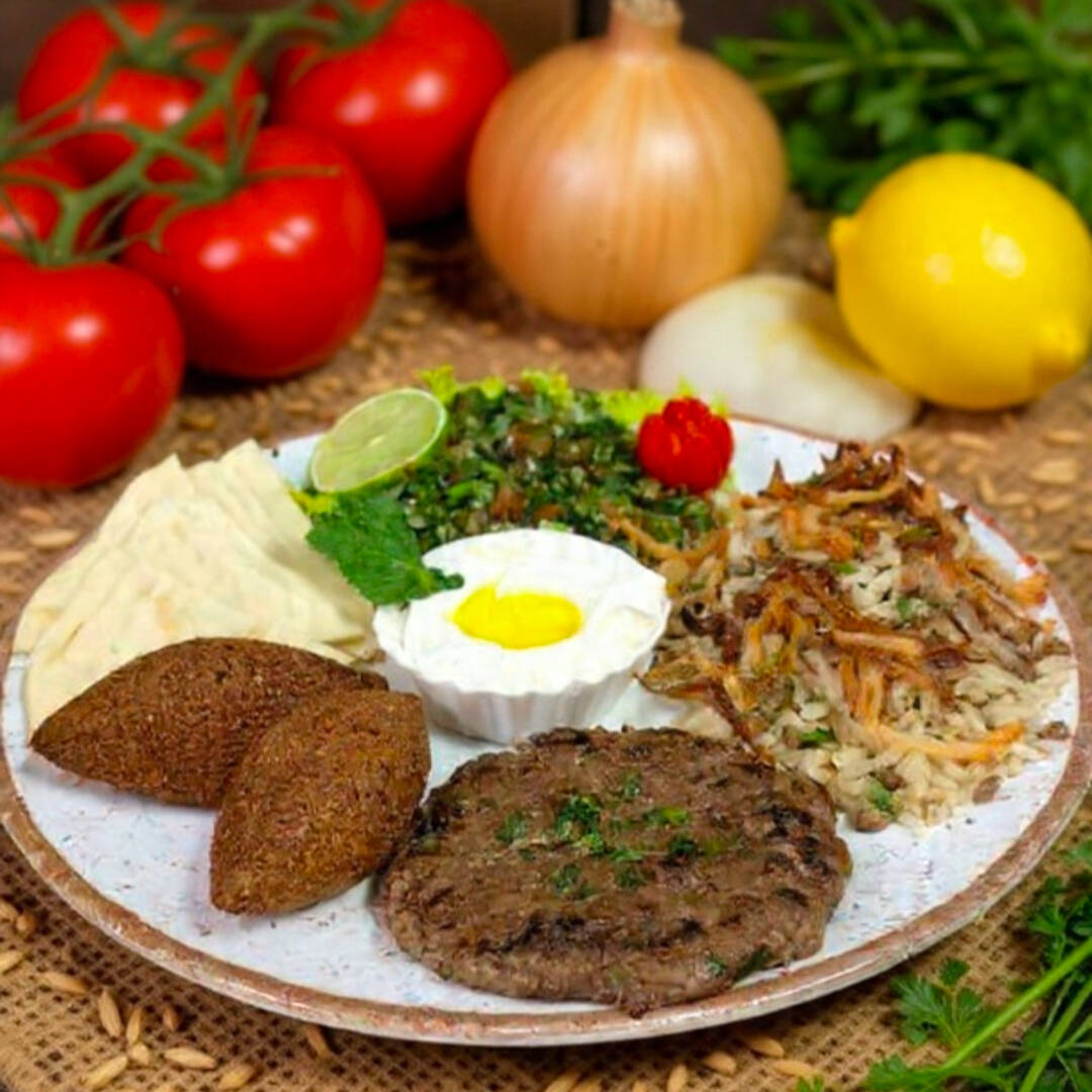 Arroz com lentilha, acompanha cebola frita, 2 kibinhos fritos recheados de carne moida, 1 Kafta assada, pão sírio, tabule e coalhada seca.