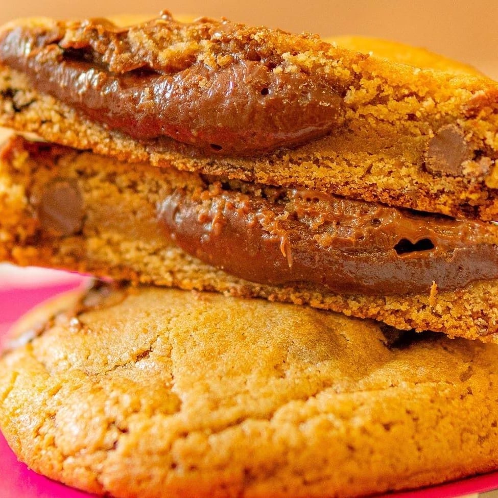 Nosso cookie feito com massa tradicional de baunilha, mix de gotinhas de chocolate meio amargo e chocolate ao leite, suuuper recheado com nosso brigadeiro artesanal de chocolate ao leite! Recomendação: indicamos que aqueça por 20 segundos no microondas