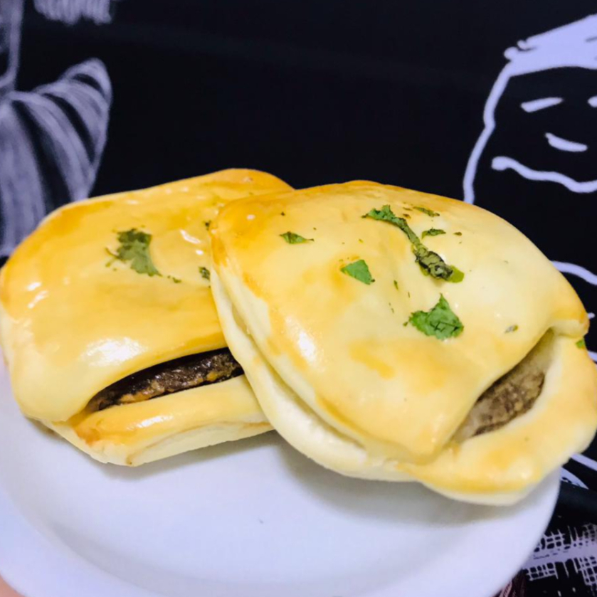 Pão de hambúrguer macio com queijo derretido por cima, ideal para um lanche saboroso.