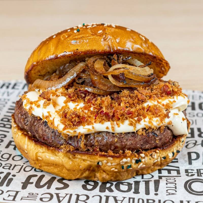 smash de cupim apresentado ao pao brioche selado na manteiga com cream chesse bacon cebola caramelizada