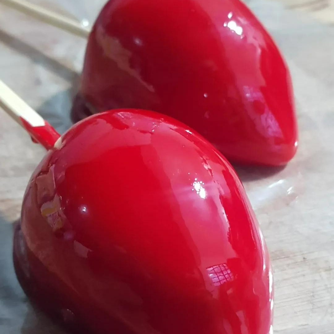 um morango envolto no brigadeiro de ninho com uma casquinha de caramelo em volta