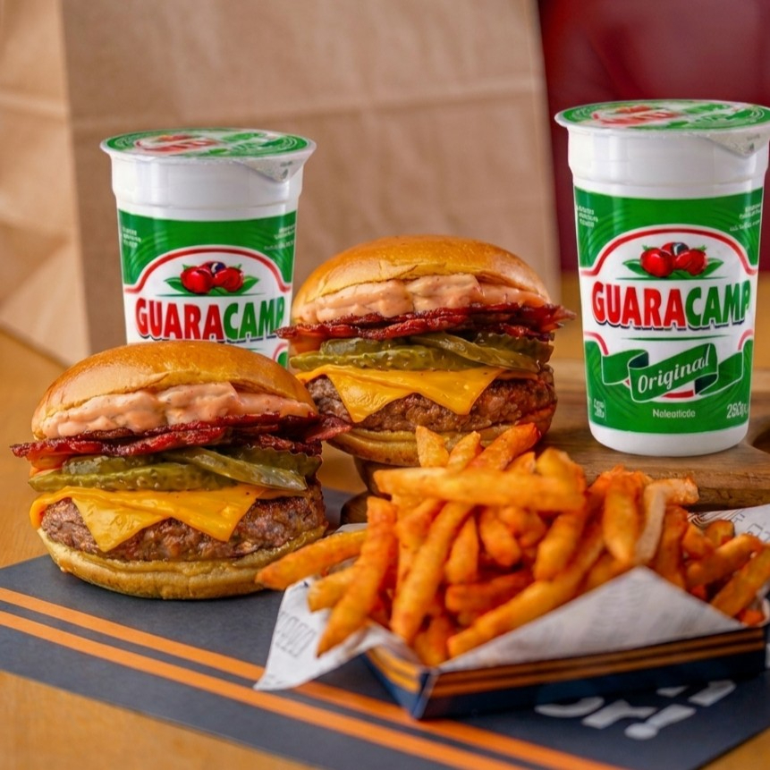 2 burgers artesanais Djavan 130g com pão macio, carne suculenta, 2 fatias de cheddar, bacon crocante, picles e maionese tasty exclusiva, acompanhados de uma porção de batata frita crocante e 2 bebidas geladas.🔥 Perfeito pra dividir — mais sabor e economia em um só pedido.