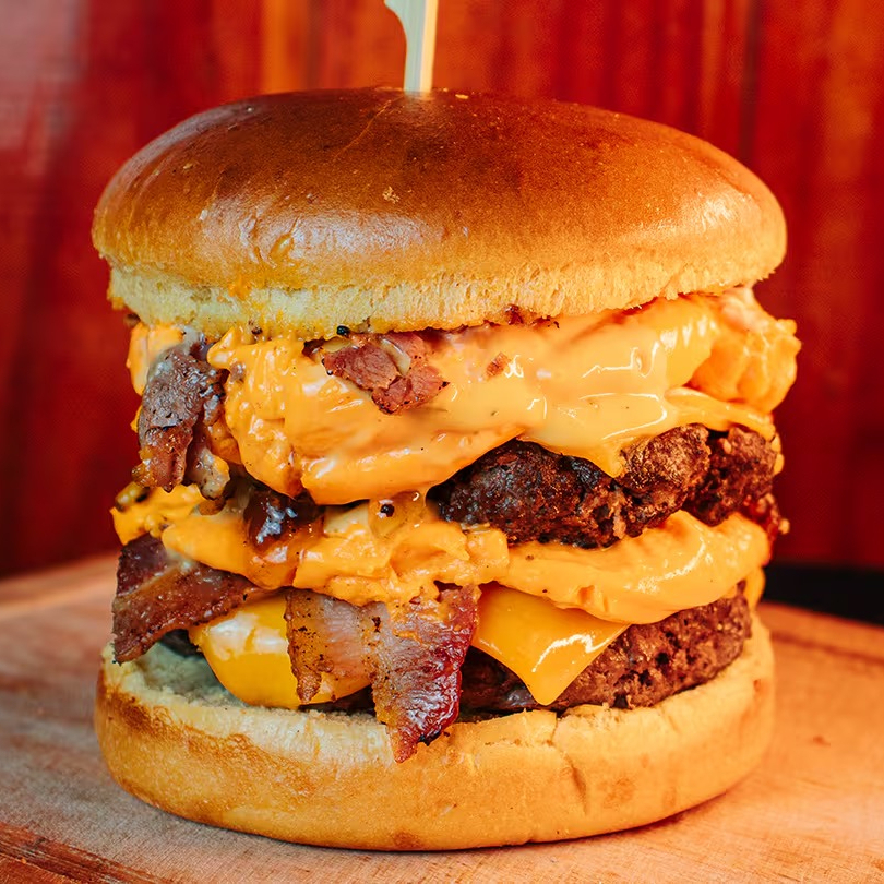 Duplo Cheddar Burguer: 02 hambúrgueres de 150g, cheddar cremoso, cebola crispy, bacon crocante, cebola caramelizada e molho da casa. Uma explosão de sabores em cada mordida!