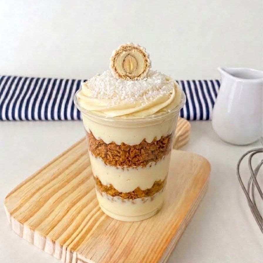 Camadas de cremoso recheio de chocolate branco, intercaladas com nosso pailleté feuilletine artesanal, trazendo uma crocância irresistível, e o delicioso recheio de Rafaello. Cremoso, crocante e com aquele sabor inconfundível de coco e chocolate branco.