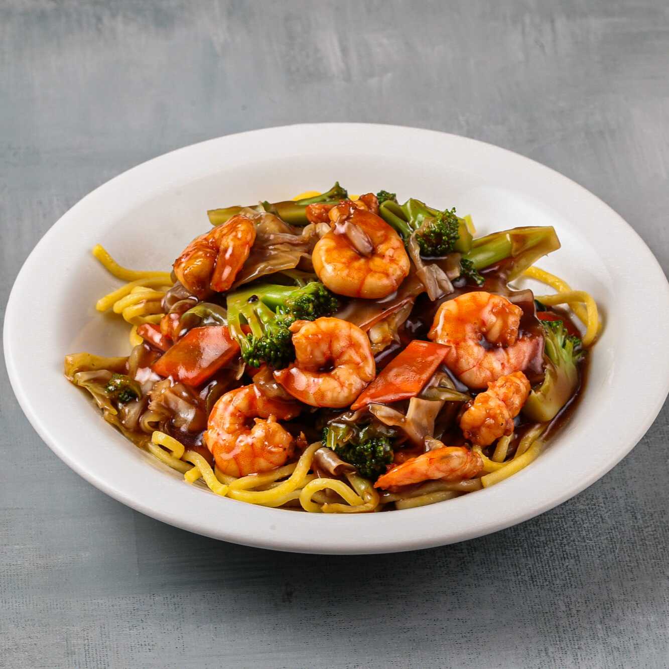 Delicie-se com nosso Yakissoba de Camarão, uma combinação perfeita de camarão suculento, legumes frescos e macarrão al dente, proporcionando uma experiência gastronômica única.
