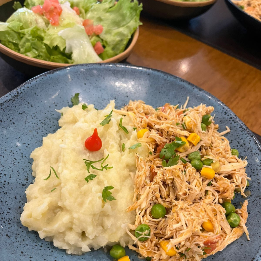 Frango desfiado com milho e ervilha, purê de batata doce e salada de folhas