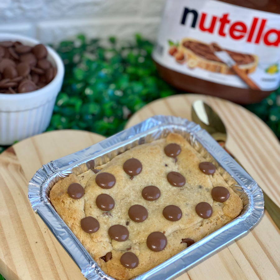 Chegou nossa tortinha de cookie, para comer de colher e se esbaldar num mundo de Nutella. Massa tradicional com gotas de chocolate e Muita Nutella.