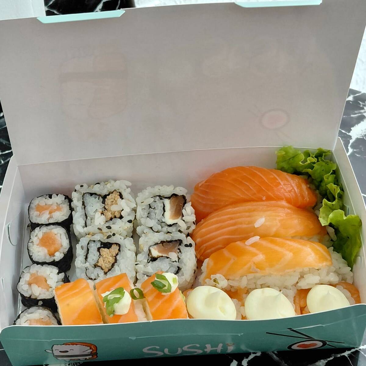 4 hossomaki de salmão, 2 uramaki grelhado, 2 uramaki salmão, 3 batera de salmão, 3 jhous de cream cheese em cima e 3 niguiris de salmão. Acompanha 2 hashis, 2 saches de molho shoyo e 2 saches de tarê.