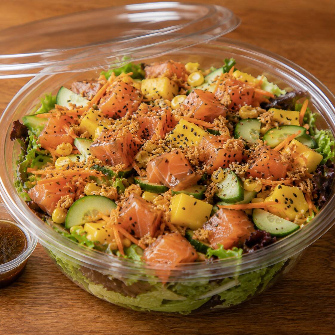 Mix de folhas, salmão cru em cubos, pepino japones fatiado bem fininho, cenoura ralada, milho, alho frito e molho ponzu