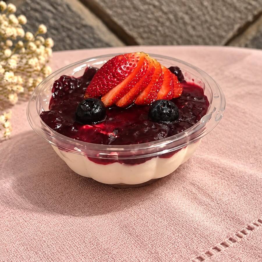 Um delicioso mini cheesecake com cobertura de frutas vermelhas frescas, perfeito para quem ama um toque azedinho.