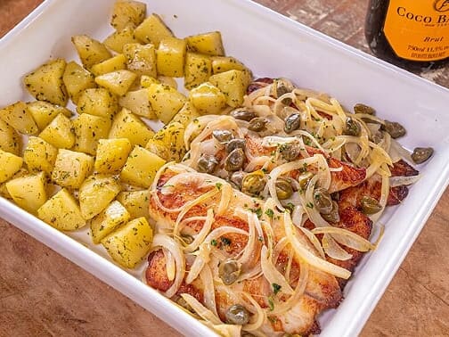 Filé de tilápia grelhado com cebolas, alcaparras e salsinha. Acompanha arroz de alho e batata soutê.