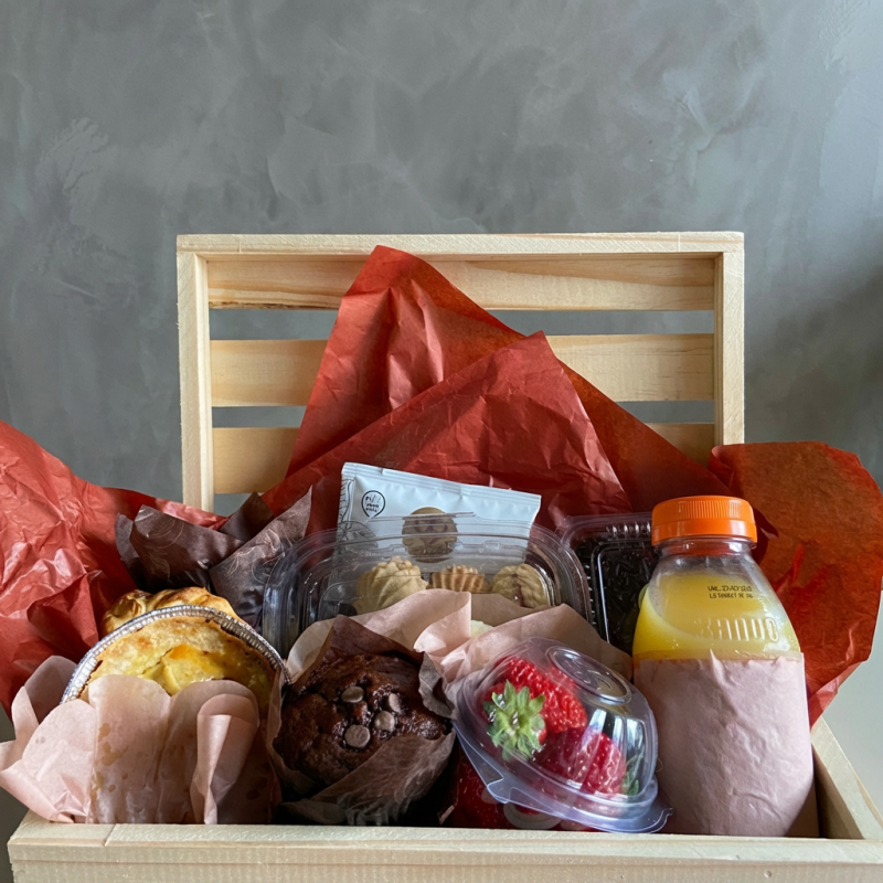 Um café completo para presentear quem você mais ama! Contém: uma cesta de madeira ,2muffin, 4 mini pães de queijo, 2 salgados, 1 doce, 1 fruta da estação, 1 pote de biscoitinhos, 1 bebida e 1 sachê de café gourmet.