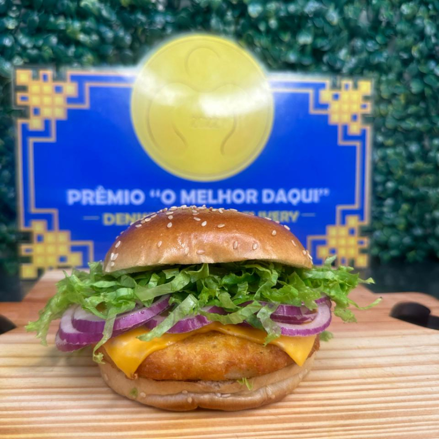 Pão, hamburguer de frango empanado, queijo cheddar, alface e cebola roxa.