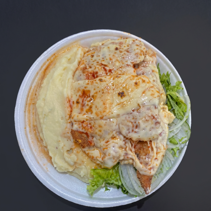 Frango à Parmegiana com purê : uma deliciosa combinação de sabores autênticos. O frango, suculento e crocante, é empanado e coberto com um molho de tomate caseiro e queijo parmesão derretido, criando uma camada irresistível de sabor. Acompanha batatas fritas crocantes, arroz branco soltinho e feijão fresco, que acrescentam uma nota de conforto a este prato. Para completar, uma refrescante salada de folhas frescas. Um prato cheio de tradição, perfeito para aqueles que apreciam a autêntica cozinha caseira.